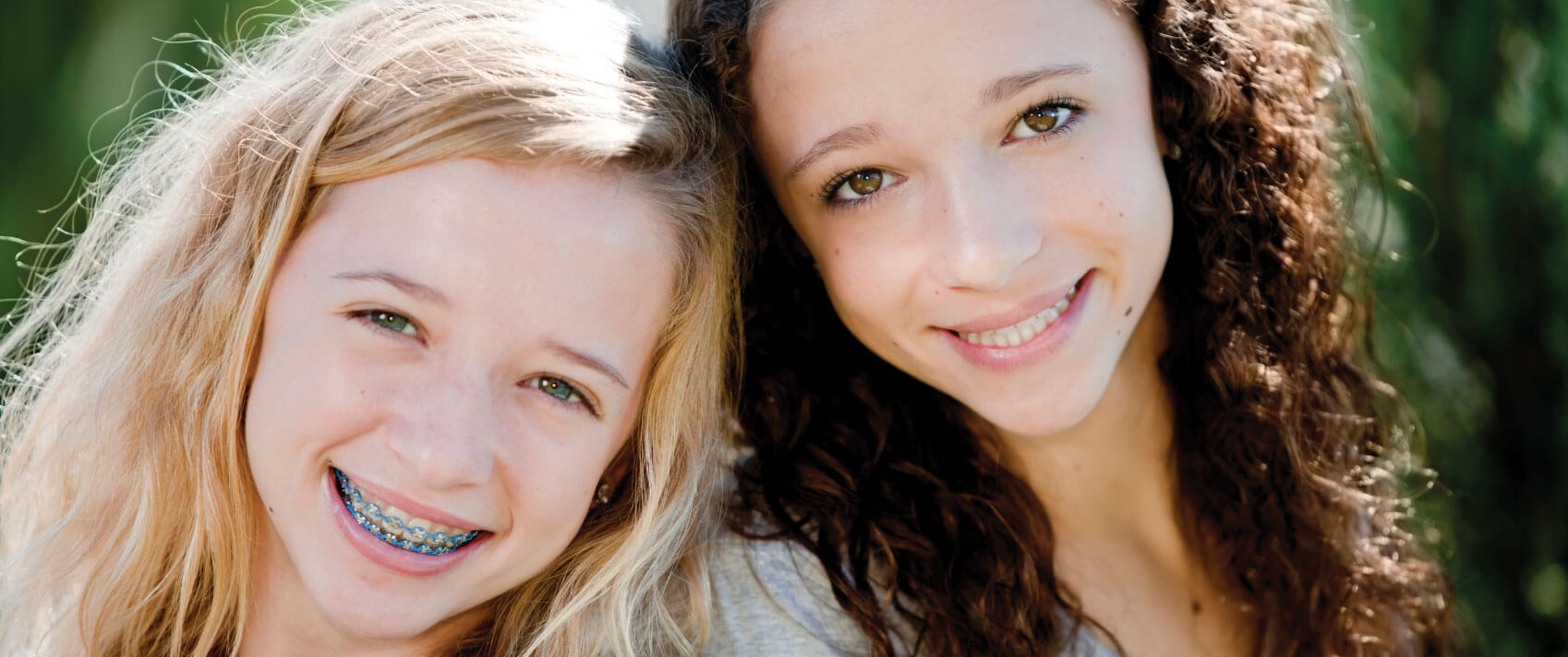 two girls smiling outside