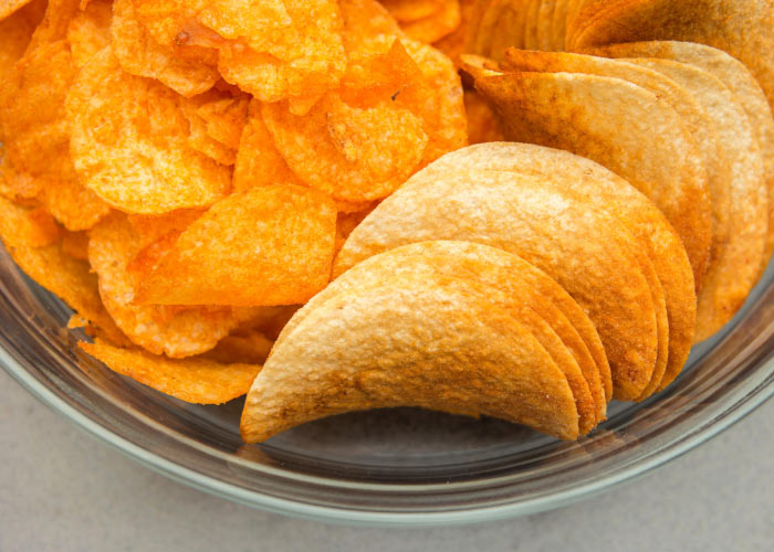 Closeup of a cluster of orange potato chips that are unhealthy for teeth